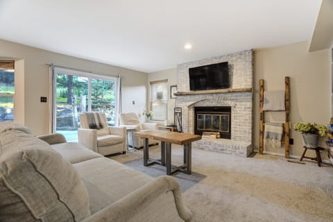 Inviting main living room with a comfortable sofa, smart TV, and sliding glass doors opening to the backyard, the perfect place to relax after a day of exploring.