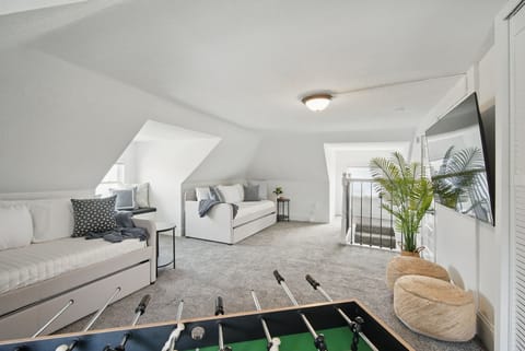 Versatile upstairs lounge with twin daybeds, foosball table, and smart TV!  Great for game nights or extra sleeping space for the group.