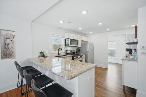Fully stocked kitchen with stainless appliances, granite countertops, and bar seating—perfect for cooking, snacking, or sipping wine.