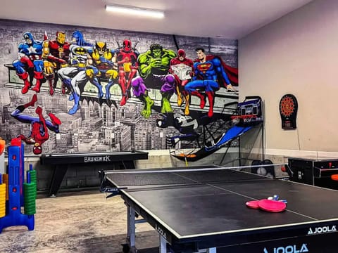 Epic game room featuring a massive 20’ x 10’ superhero mural—where every night feels legendary.