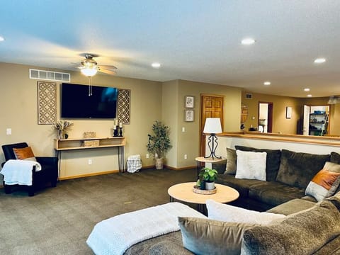 Large living room with sectional couch and  large TV. 