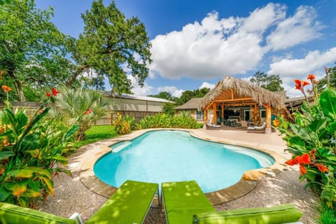 Escape to your private paradise featuring a sparkling pool, lush landscaping, and shaded cabana seating.