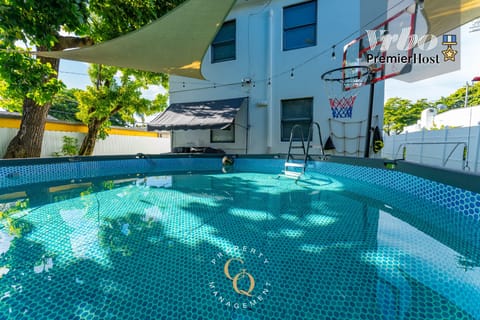 Private pool under trees with comfy seating and peaceful backyard views.