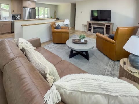 A comfortable living area invites relaxation with its cozy sofas and access to a well-equipped kitchen, perfect for entertaining.
