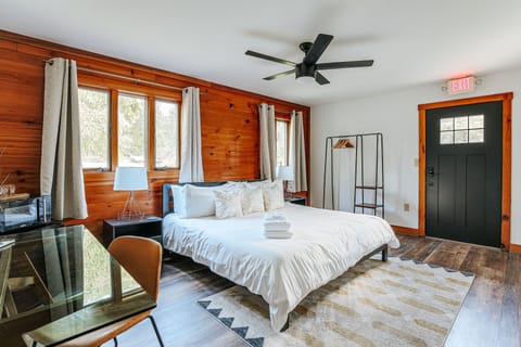 Cozy ADA-accessible bedroom with a king bed, desk, and large windows for natural light.