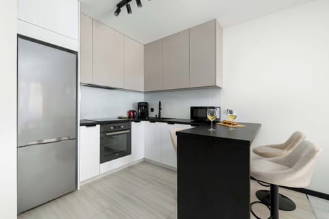A sleek open kitchen with a dining table and chairs.