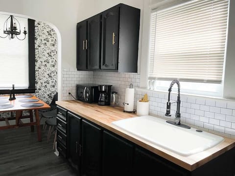 Butcher block kitchen counter with a large farmhouse sink. A nice spot to put together your favorite meal.