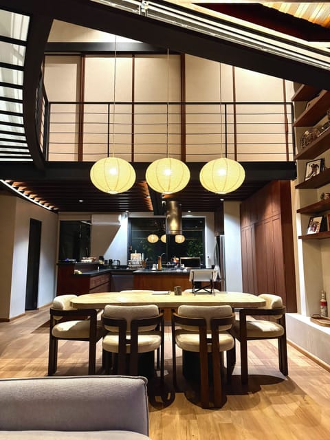 Dining at night with Master BR doors closed. 2-story library. Full open kitchen.