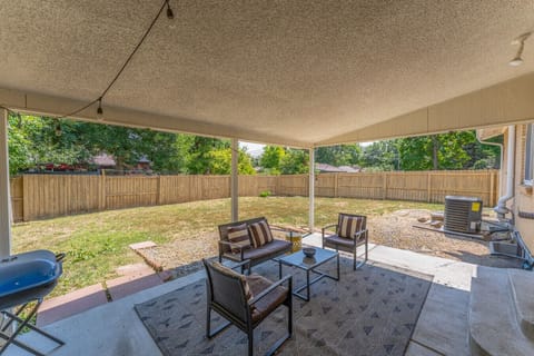 Covered back patio with seating and large, fully fenced yard