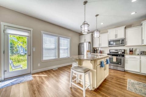 Bright and airy gourmet kitchen is open to the separate dining room and living room. Door exits to patio with outdoor seating, grill, and shared firepit