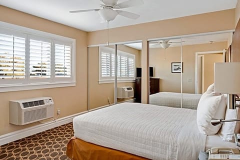 Unwind in crisp linens beside bright shutters and quiet views.