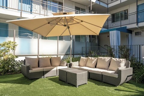 Lounge together on plush outdoor sofas beneath oversized umbrellas.