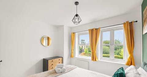This bright and airy bedroom is perfectly designed to feel both modern and incredibly welcoming, especially with the natural sunlight pouring in through the large windows. The crisp white walls create a clean and spacious atmosphere.