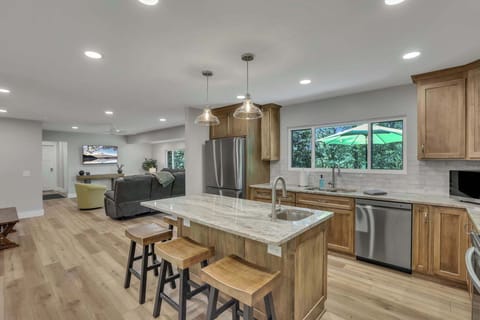 A stunning, fully equipped kitchen flows effortlessly into the living and dining spaces, opening onto the back deck for indoor-outdoor enjoyment