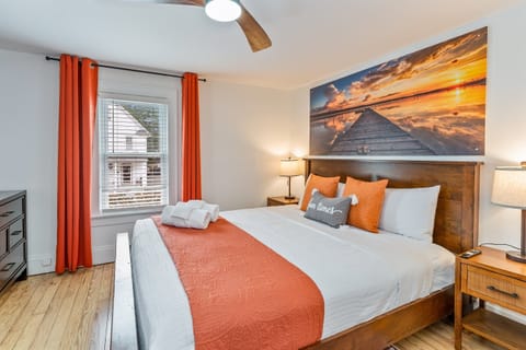 Wake up to calming vibes in this king suite with sunset artwork, warm lighting, and plush bedding. Bedroom #1 upstairs 