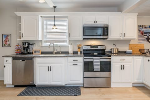 Spotless and stylish kitchen with stainless steel appliances, coffee station, and modern lighting—perfect for your Finger Lakes getaway!
