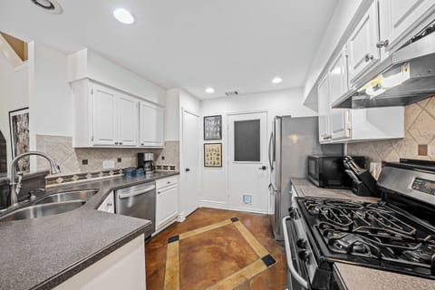 Full kitchen view of stove fridge door to garage pantry dishwasher and sink
