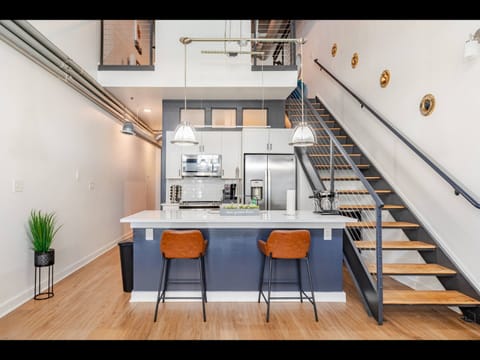 Stylish loft kitchen with island seating & open staircase design