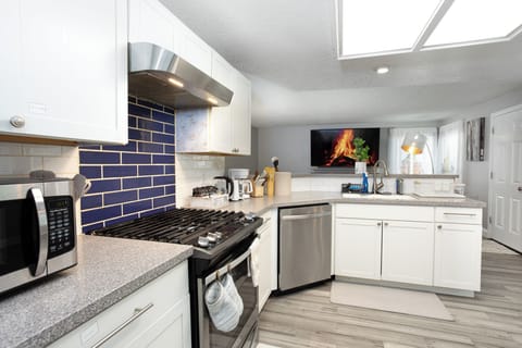 Kitchen with refrigerator, cooking stove, oven, microwave, cooking utensils