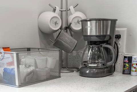 Coffee corner with a drip coffee maker, mugs, and supplies to start your mornings right.