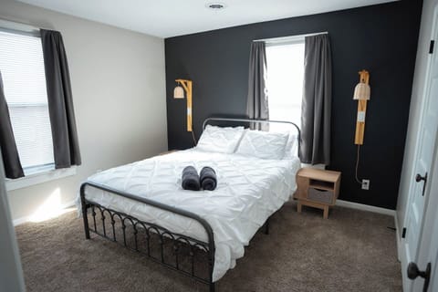 The bedroom has a comfy queen bed with fresh linens and plenty of pillows. Two nightstands with lamps make it easy to read or relax before bed. Curtains keep the space private and cozy, so you can get a good night’s rest.