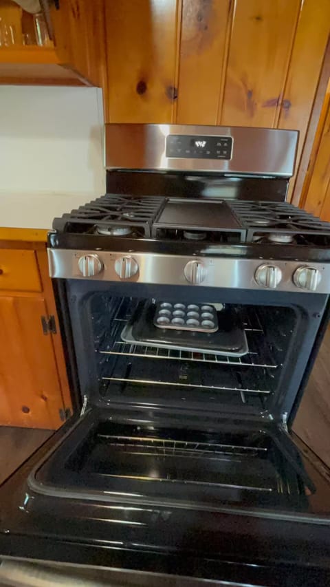 A fully stocked kitchen with stove, refrigerator, microwave, pots & utensils.