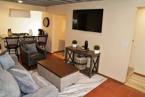 Living Room - Seating Area Leads into Kitchen, TV, Island with Seating, and Stairs