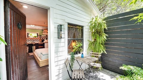 Tucked beneath the trees, this cozy patio is the perfect spot to sip coffee or unwind with a book. Step inside to a bright, stylish space that blends comfort and charm for a peaceful stay.
