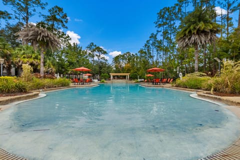 A serene resort-style pool framed by palm trees and blue skies—pure vacation bliss.