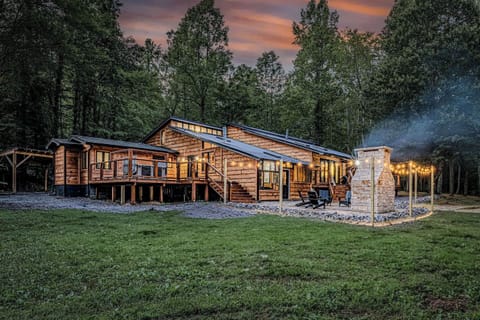 Your private mountain sanctuary comes alive at night with illuminated decks, a grand outdoor fireplace, and a spa-like hot tub designed for long, peaceful soaks under the stars.