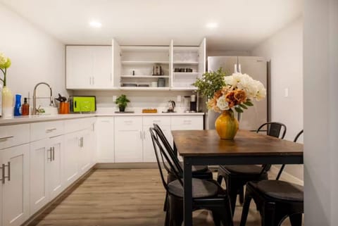 Bright and modern kitchen with ample storage, stainless steel appliances, and a cozy dining space accented by fresh flowers🌸🍴✨
