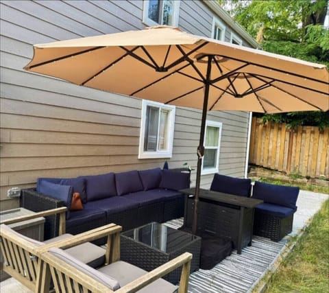 Enjoy the perfect outdoor hangout spot—comfortable seating, a shaded umbrella, and a cozy fire table for relaxing day or night.