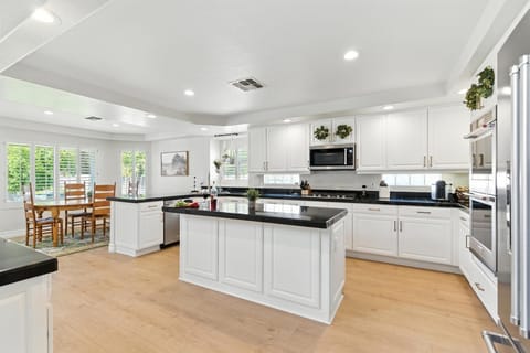 Fully equipped kitchen with stainless steal appliances, kitchen island, and snow cone machine.