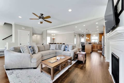 Living room with a view of kitchen, dining and stairway.
