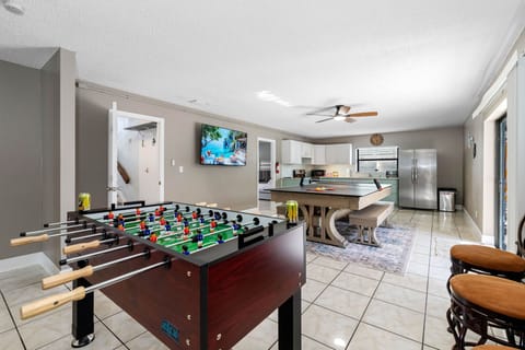 This open-concept area is perfect for family fun, with a full kitchen, foosball, and a convertible ping pong/dining table—plus sliding doors that lead right to the backyard.
