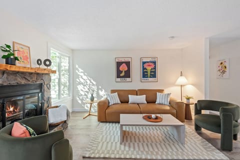 Cozy up in the bright, stylish living room with fireplace, plush seating, and calming natural light.