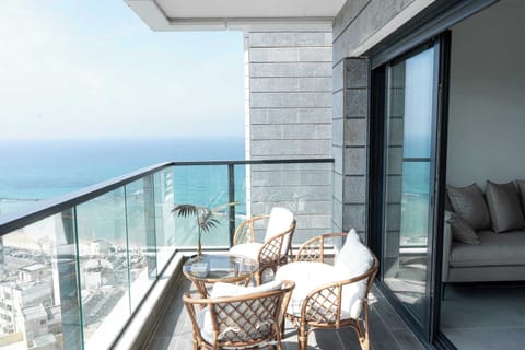 Private balcony seating invites sunrise coffee with sweeping sea views moments from the beach below.