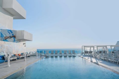 Dive into oceanfront serenity with sunlit rooftop pool views.