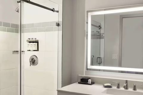 Rinse off in a sleek, glass shower with bright vanity.