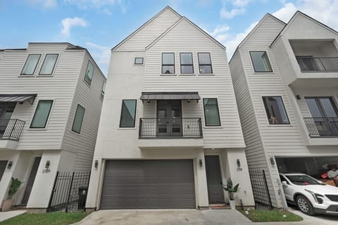 Modern three-story home with private garage, balcony, and sleek design