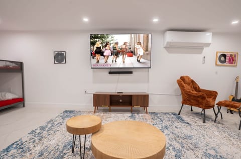 Basement entertainment zone with TV, cozy lounge chair and bunk beds, perfect for family fun