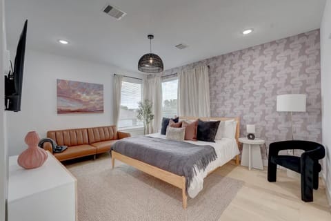 Relax in this stylish bedroom featuring chic wallpaper and comfortable seating.