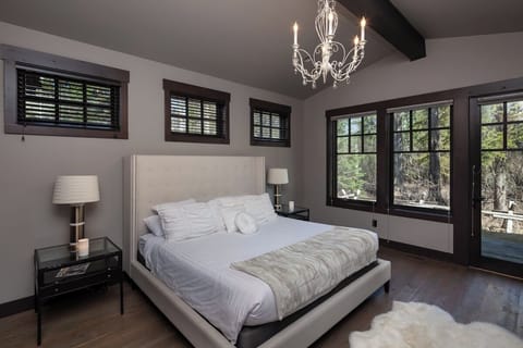 Unwind in a sunlit king bedroom with serene forest views.