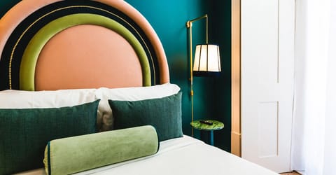 Relax against velvet pillows beneath the bold, curved headboard
