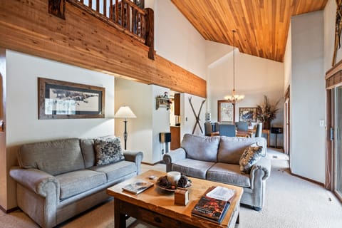 - Open living and dining area with vaulted wood ceilings  
- Comfortable sofas and rustic furniture for cozy evenings  
- Sliding doors bring in natural light and scenic views
