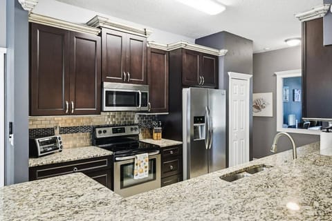 Fully equipped modern kitchen with coffee options, ample counter space, and stylish appliances—cook & entertain with ease.