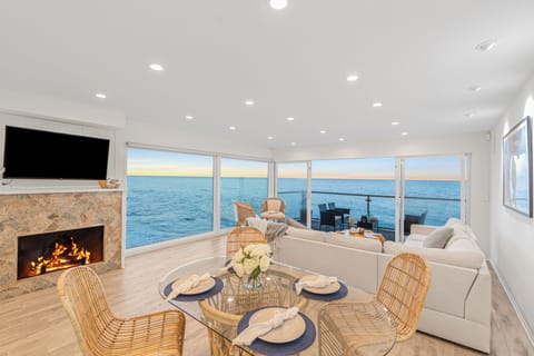 Inviting living room featuring a fireplace, TV, and panoramic ocean vistas.