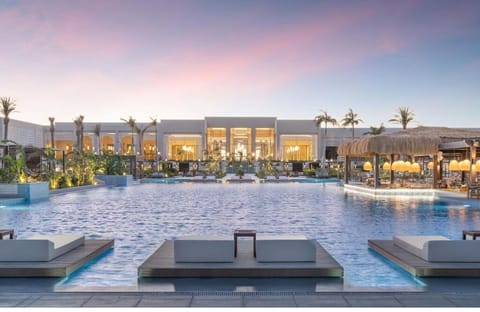 Soak in sunset serenity beside the shimmering lagoon pool.