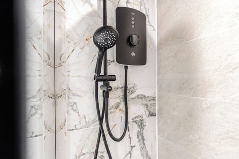 The full bathroom features a sink, toilet, and electric shower, offering a clean and comfortable space to refresh during your stay.
