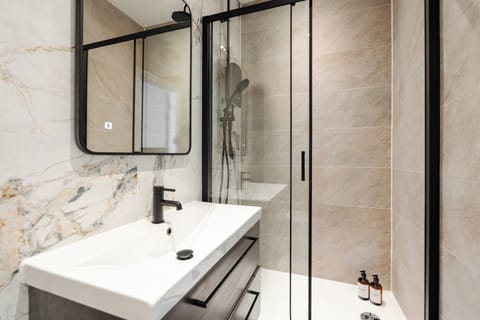 The full bathroom features a sink, toilet, and electric shower, offering a clean and comfortable space to refresh during your stay.
